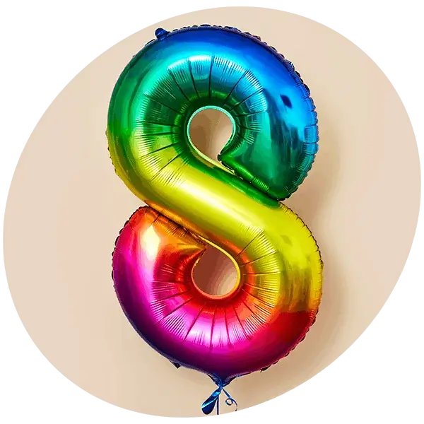 A colourful assortment of birthday foil balloons, including a cake, a castle, stars, and number shapes against a blue background.