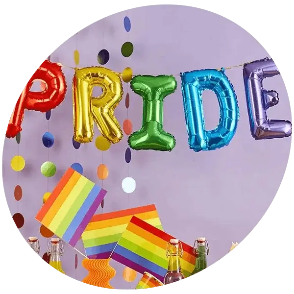 Pride party setup with colourful balloon letters spelling PRIDE, rainbow flags, confetti decorations, and drinks on display