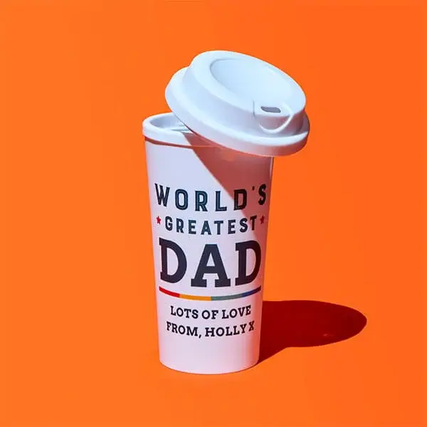 White travel mug on an orange background with the text World’s Greatest Dad and a personalised message from Holly X