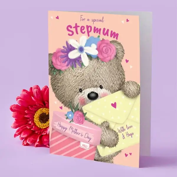 A peach-coloured Mother’s Day card featuring a cute teddy bear holding envelopes and flowers, with decorative hearts and a bright pink flower beside it.