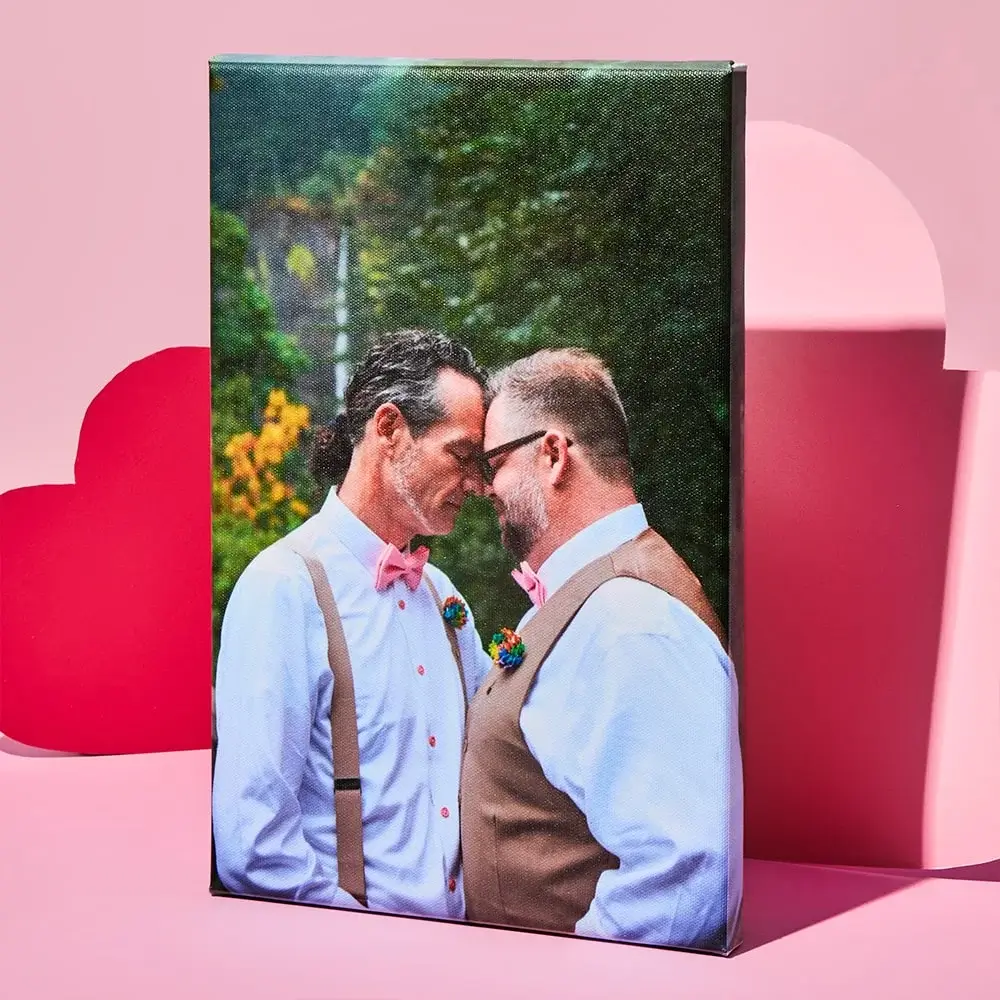 Black photo frame with a heart-shaped cutout at the top and three smaller rectangular photos below, featuring the text Bryan and Jen on a white background, set against a pink backdrop with heart shapes.