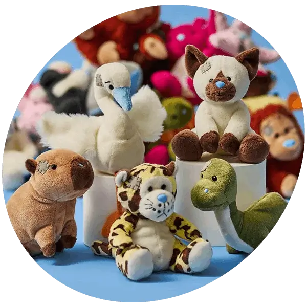 Selection of plush soft toy animals including a swan, cat, tiger, dinosaur, and capybara displayed on a blue background.