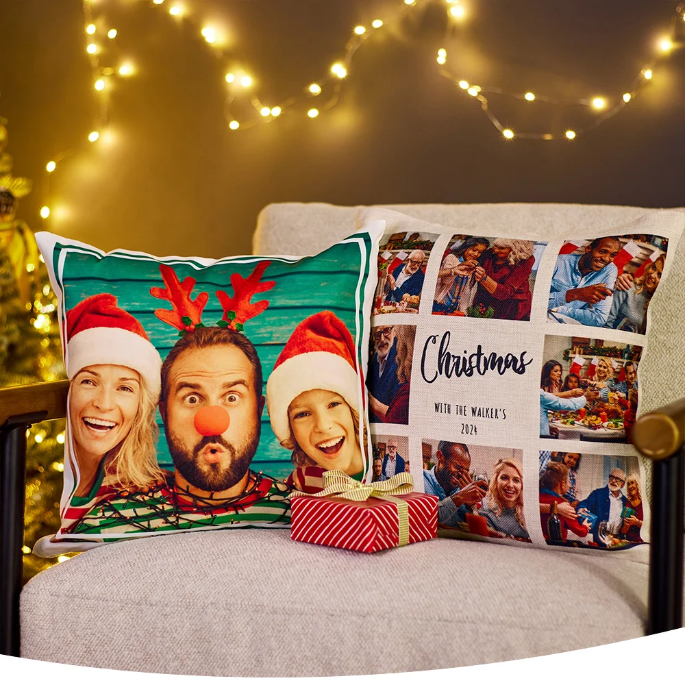 Two Christmas cushions on a chair—one with a festive family photo and the other with a photo collage and the text 'Christmas with the Walker's 2021', with a small wrapped gift and fairy lights in the background.