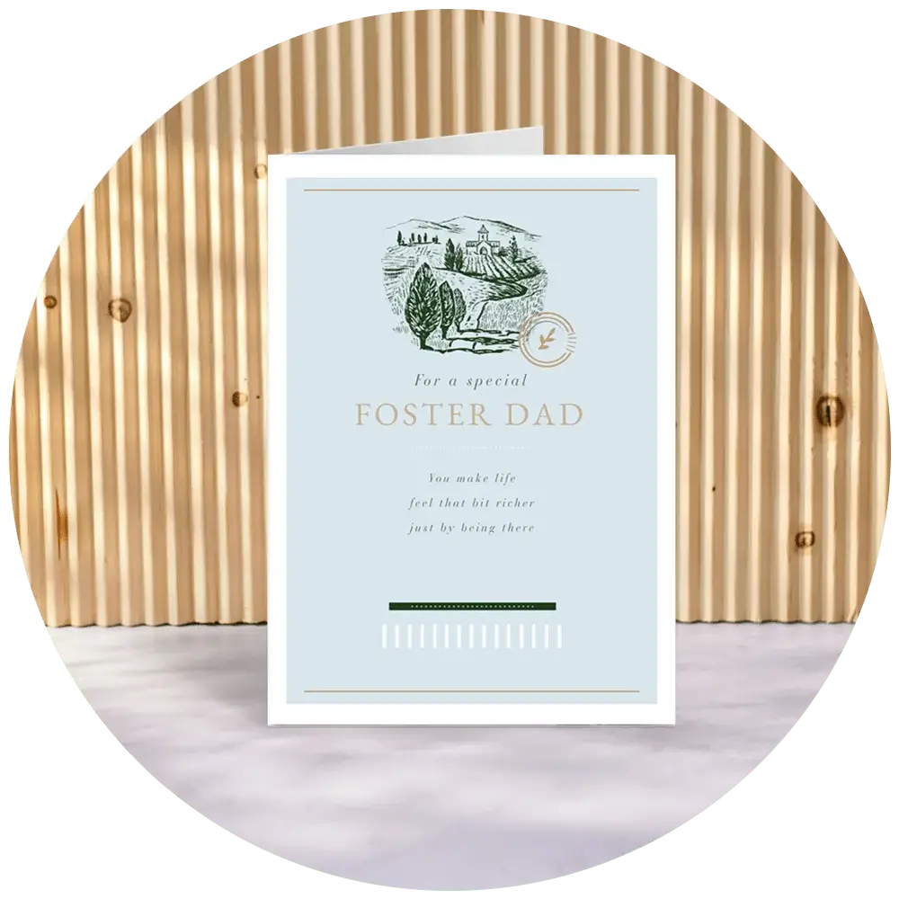 A greeting card for a foster dad with an illustration of a landscape featuring trees and hills, and the text 'For a special FOSTER DAD. You make life feel that bit richer just by being there.' The card is displayed against a ribbed wooden background.' A greeting card for a foster dad with an illustration of a landscape featuring trees and hills, and the text 'For a special FOSTER DAD. You make life feel that bit richer just by being there.' The card is displayed against a ribbed wooden background.'