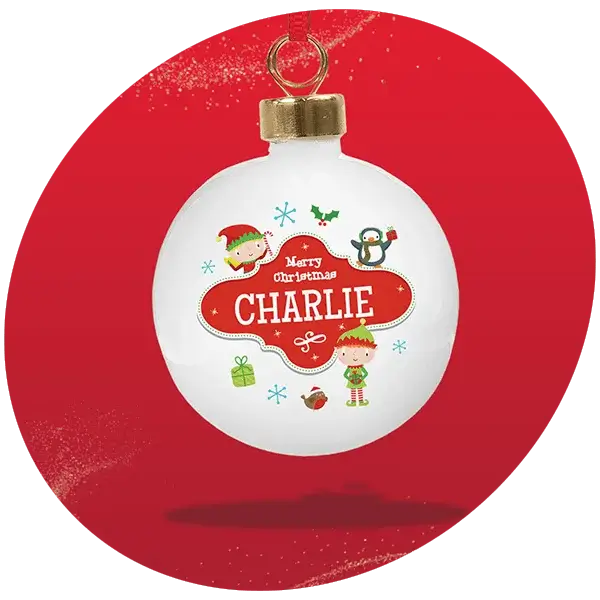 White Christmas bauble with gold cap and red ribbon, decorated with festive illustrations including elves, a penguin, holly, snowflakes, a gift box, and an ornament, set against a solid red glittery background with the text Merry Christmas CHARLIE in red and white.