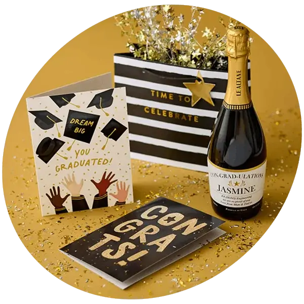 Graduation celebration display with congratulations cards, a personalised sparkling wine bottle, gold confetti, and festive gold decorations.