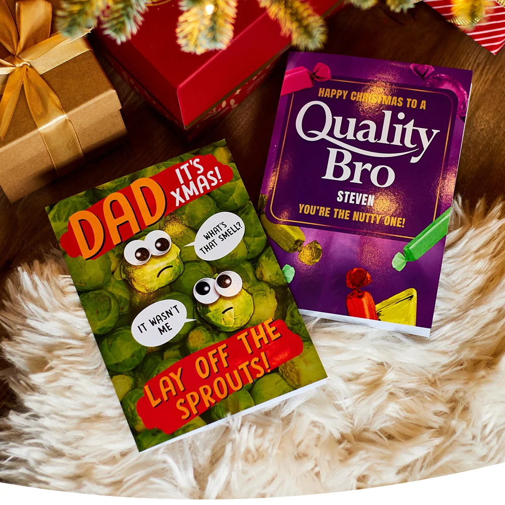 Funny Christmas cards on a fluffy rug, one with cartoon sprouts saying 'It wasn't me' and 'What's that smell?', and another reading 'HAPPY CHRISTMAS TO A Quality Bro STEVEN YOU'RE THE NUTTY ONE!'