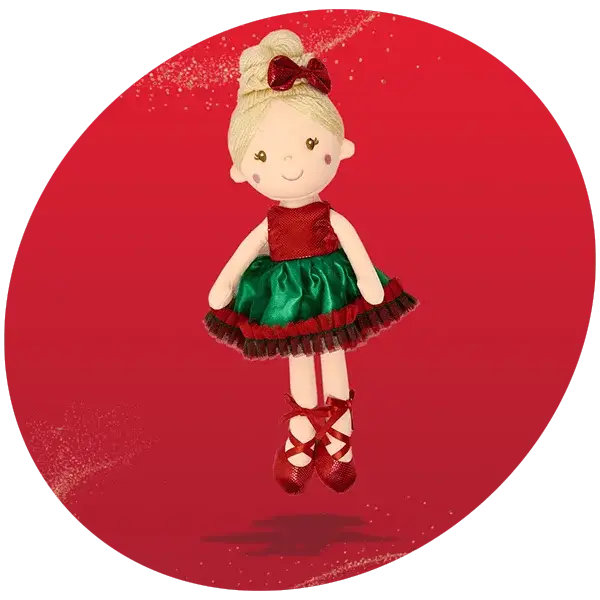 Festive plush doll with blonde hair in a bun, red bow, red and green dress with black trim, and red ballet shoes, set against a red background with gold glitter accents.