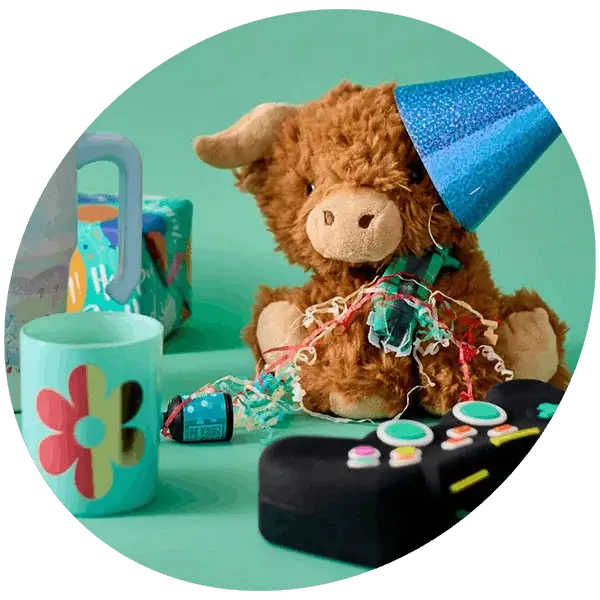 Kids party gift setup with plush toy wearing a party hat, sippy cup, and novelty toy controller on a teal background