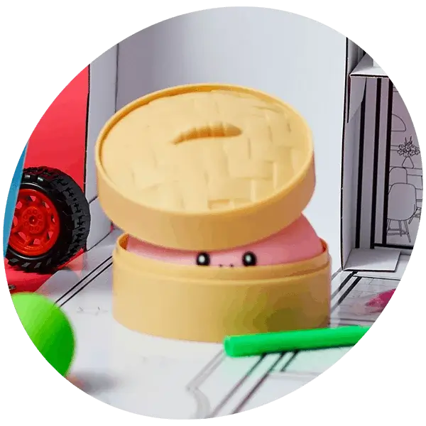 Novelty bao bun toy with a smiling face peeking from a bamboo-style steamer basket on a playful illustrated background.