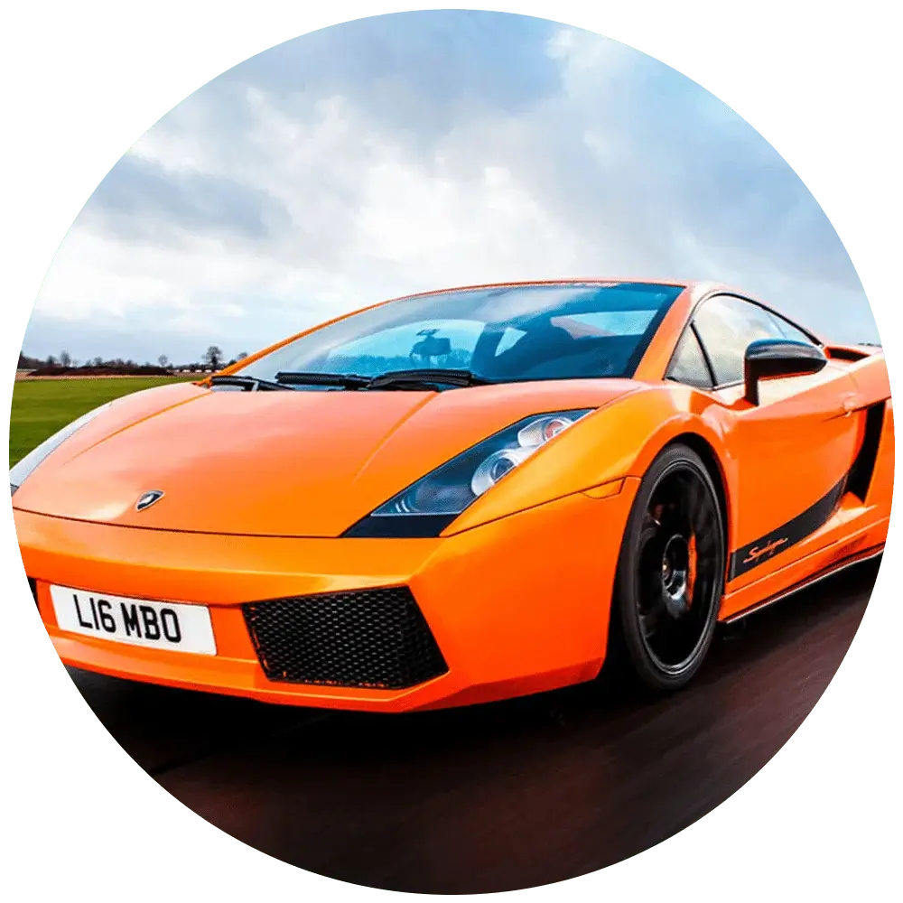 An orange Lamborghini Gallardo Superleggera is driving on a road. The car has a sleek design with black accents, including the wheels and side mirrors. The license plate reads L16 MBO. The background shows an overcast sky and a blurred landscape, indicating motion.' An orange Lamborghini Gallardo Superleggera is driving on a road. The car has a sleek design with black accents, including the wheels and side mirrors. The license plate reads L16 MBO. The background shows an overcast sky and a blurred landscape, indicating motion.'