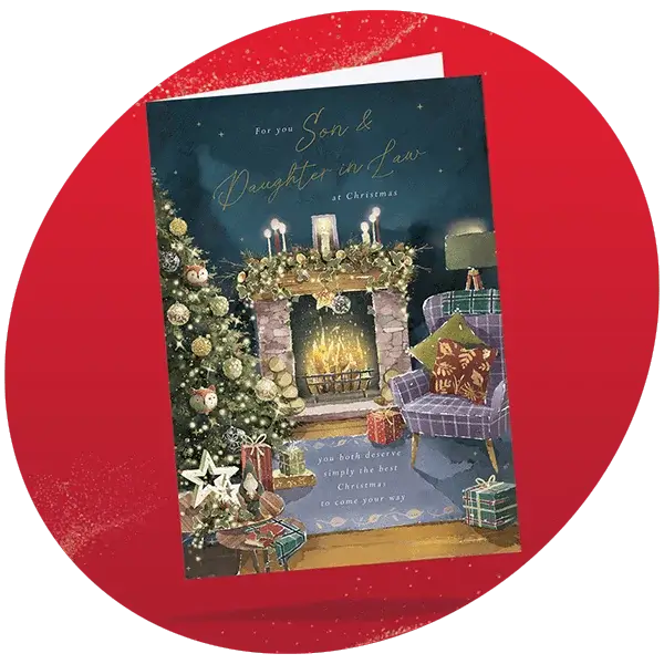 Christmas card for a son and daughter-in-law showing a cozy living room with a decorated tree, lit fireplace with candles and garlands, and two armchairs with festive pillows, featuring the text For you Son and Daughter in Law at Christmas and you both deserve simply the best Christmas to come your way.