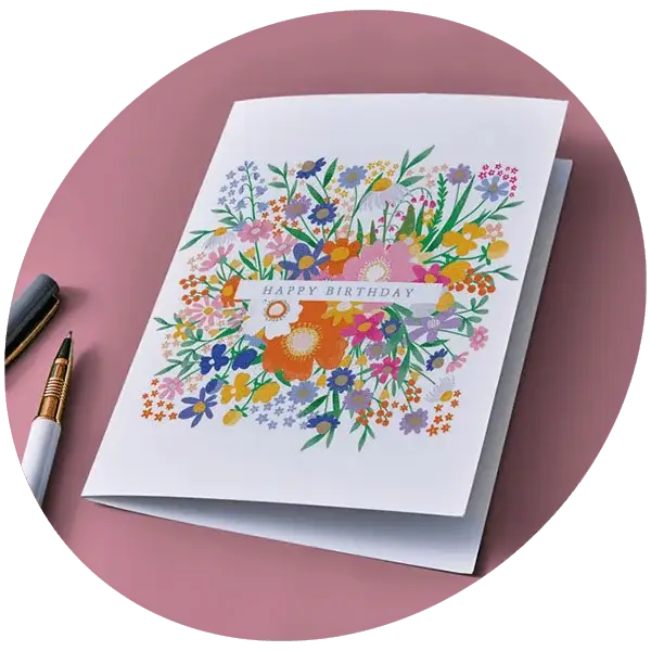 Floral birthday card with colourful illustrated flowers and Happy Birthday text on a pink background
