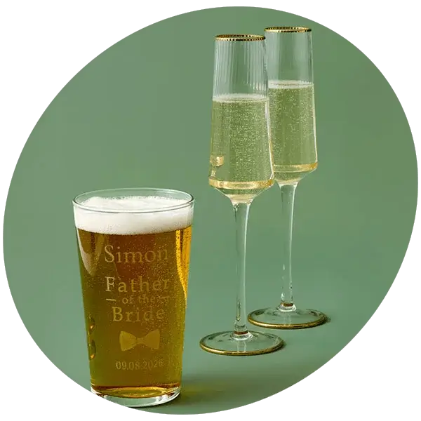 Engraved pint glass and champagne flutes displayed against a green background, ideal for wedding celebrations and personalised gifting.