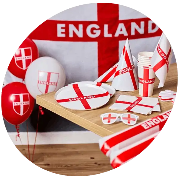 England themed party table with red and white decorations, plates, cups, balloons, and flags featuring the St George’s cross