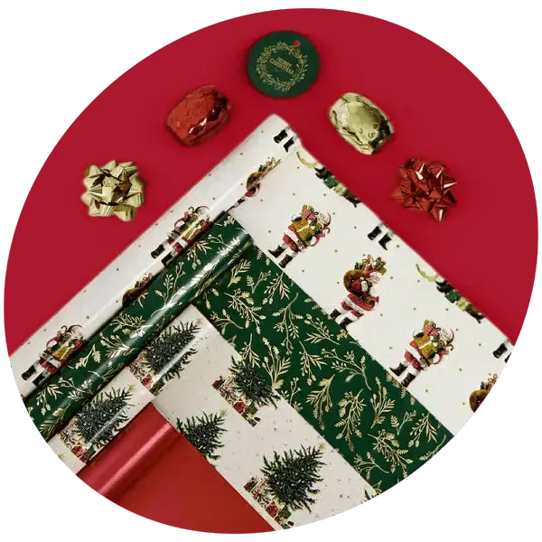 Christmas wrapping paper pack featuring festive tree, foliage and nutcracker designs, displayed with gift bows and wrapped presents on a red background.