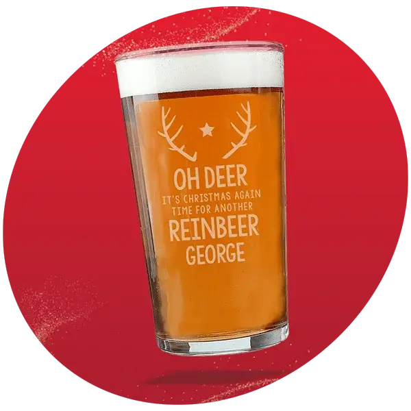 Pint glass filled with beer featuring festive antlers and star design with etched text, set against a red background with white speckles. Pint glass filled with beer featuring festive antlers and star design with etched text, set against a red background with white speckles.