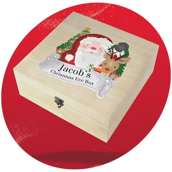 Wooden Christmas Eve box with festive design featuring Santa Claus, a reindeer, and personalized text on the lid, set against a red background.